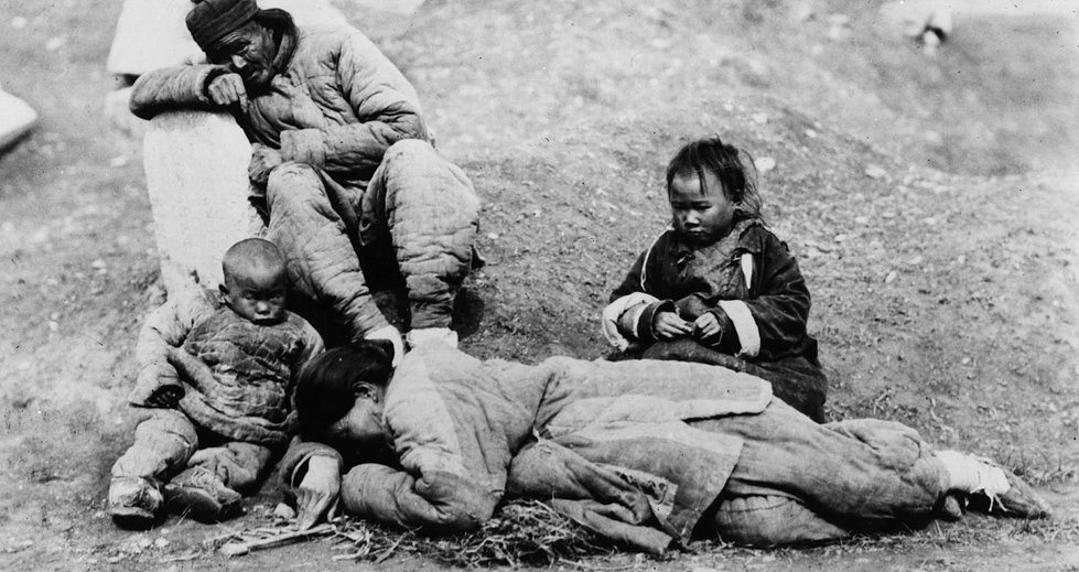 Typical famine victims in China. A man grieves while children look at dying mother. (Photo by Topical Press Agency/Getty Images)